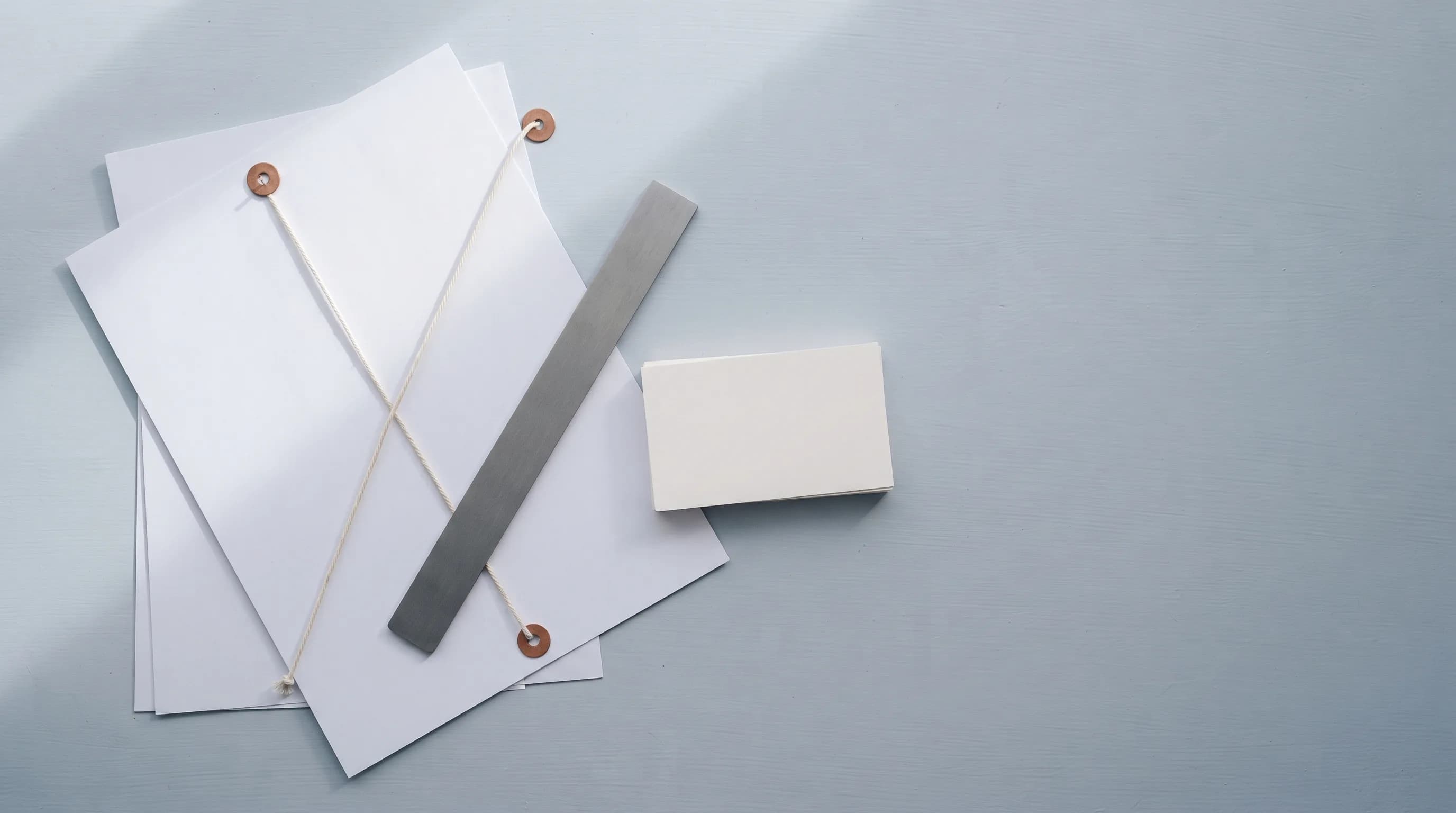 A steel tape measure pulled open diagonally across two quotation sheets.